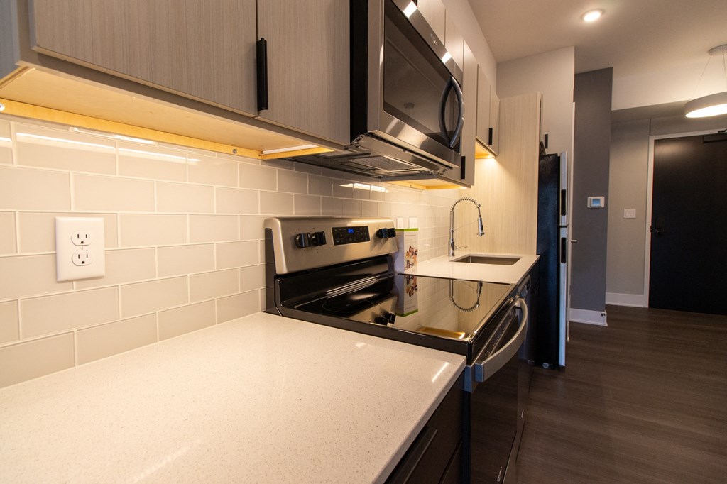 a kitchen with a counter top and a stove and a microwave