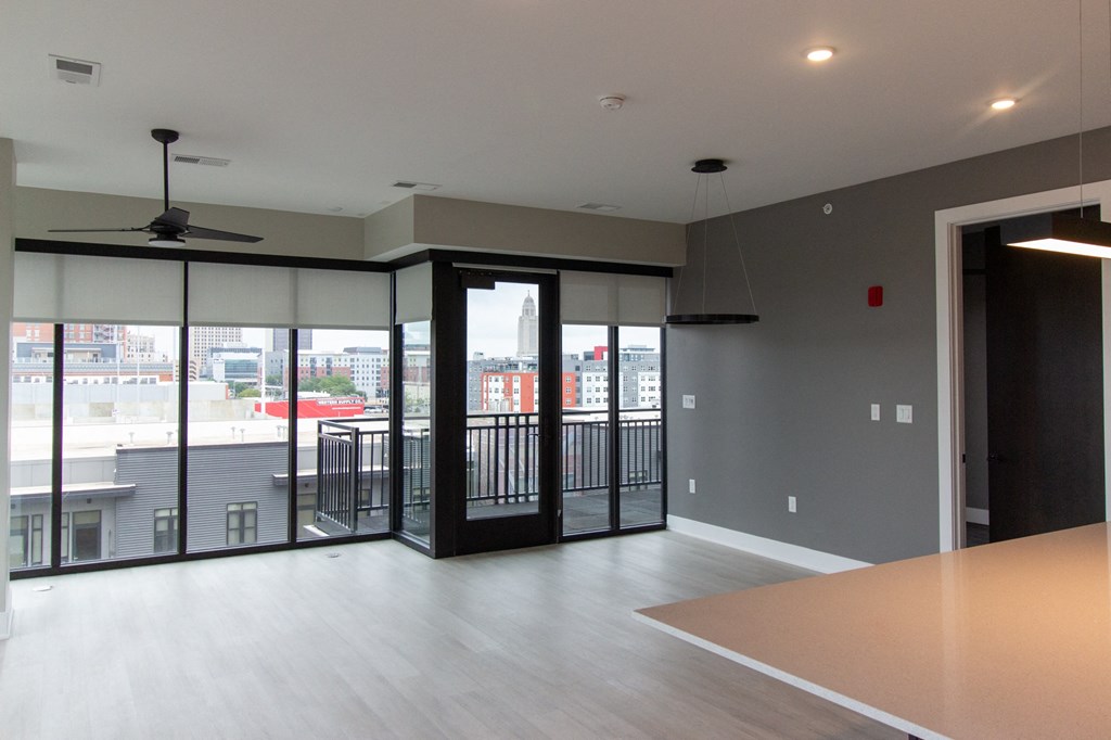 an empty living room with a balcony and sliding glass doors