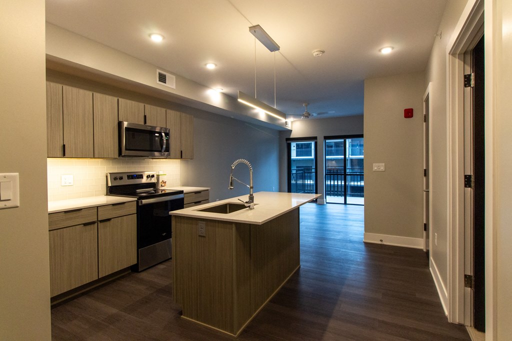 an empty kitchen with a sink and an island in the middle
