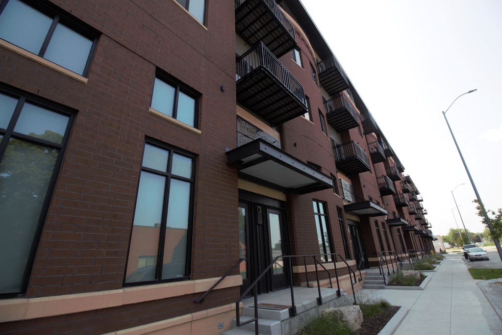 a row of new apartments on the side of a sidewalk