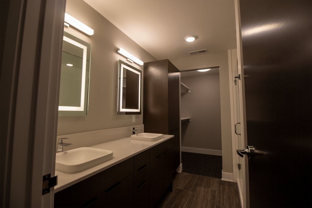 a bathroom with two sinks and a mirror and a door