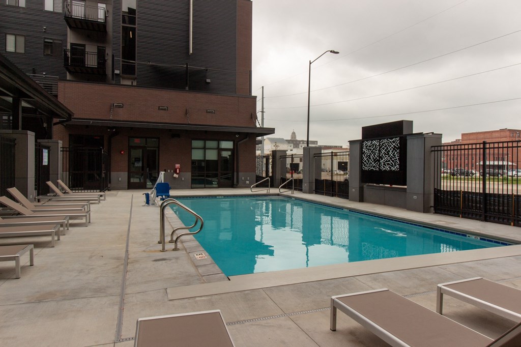 the pool on the rooftop of a building with chairs around it