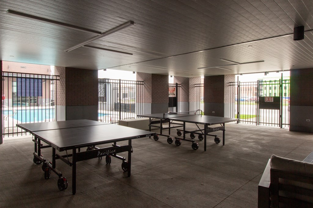 a large room with ping pong tables and a pool