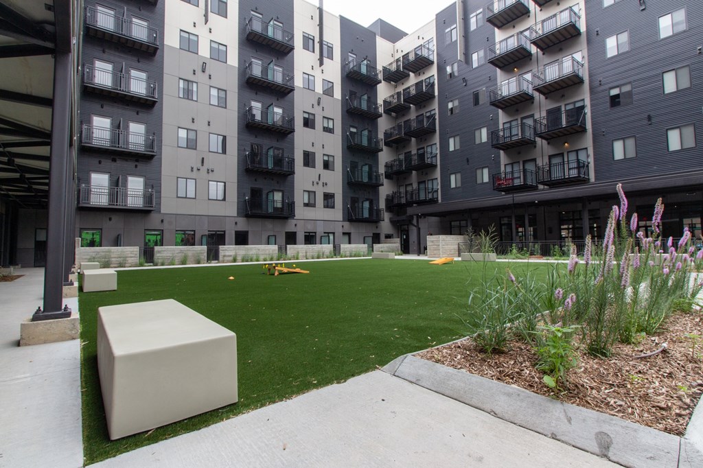 an exterior view of an apartment building with a green lawn