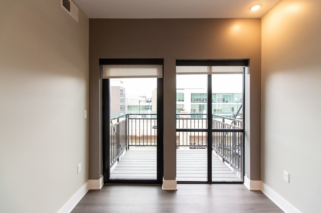 the view of a balcony from a living room with glass doors