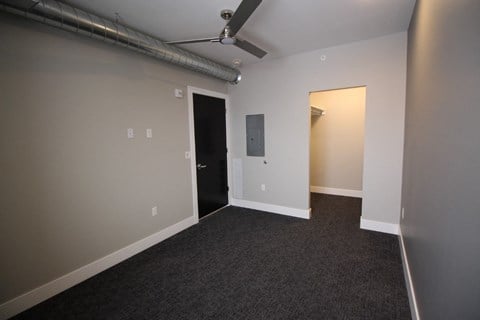 a living room with a carpet and a door to a hallway