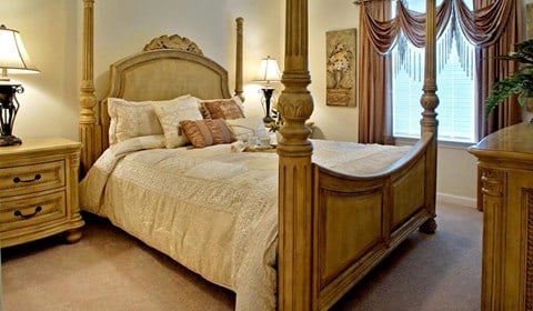 a bedroom with a four poster bed and a dresser