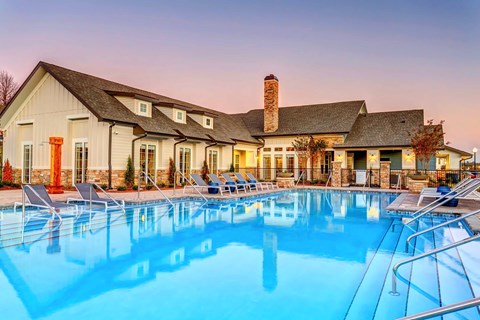 A clubhouse with a pool in front.