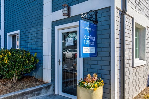 a blue building with a leasing office sign and a glass door