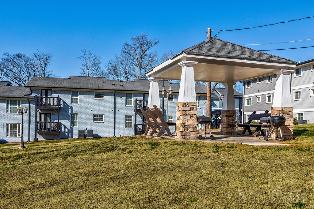 a patio with a gazebo in front of some apartments