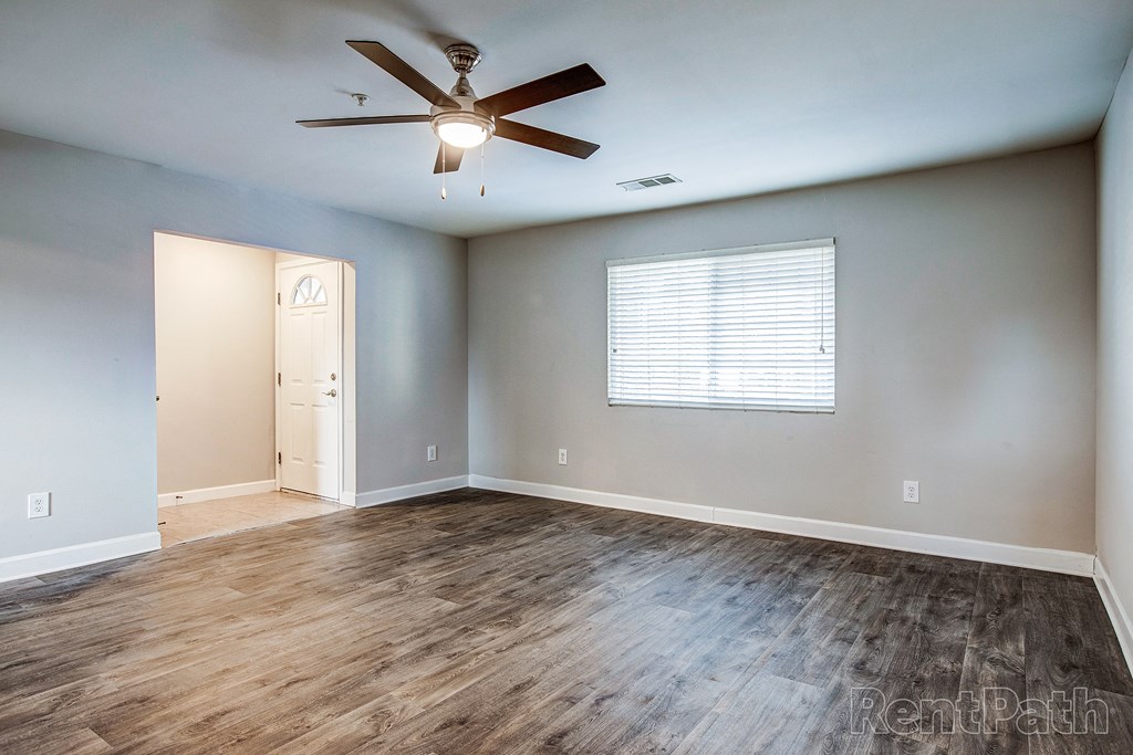 the living room of an empty house with a ceiling fan