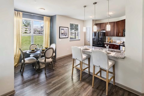 A kitchen with a dining table and chairs.
