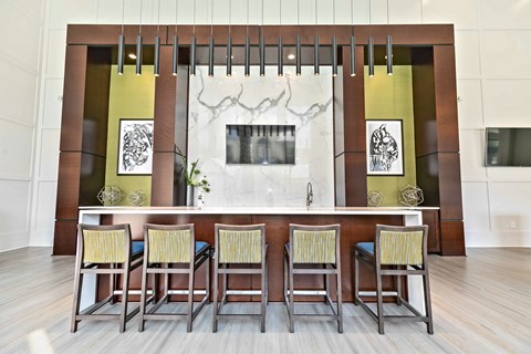 A modern clubroom with a long table and chairs.