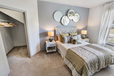A bedroom with a large bed and a mirror on the wall.