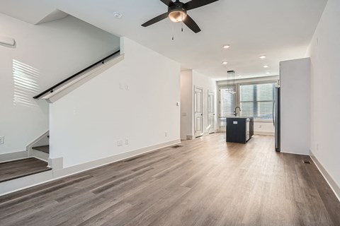 A spacious room with a ceiling fan and wooden flooring.