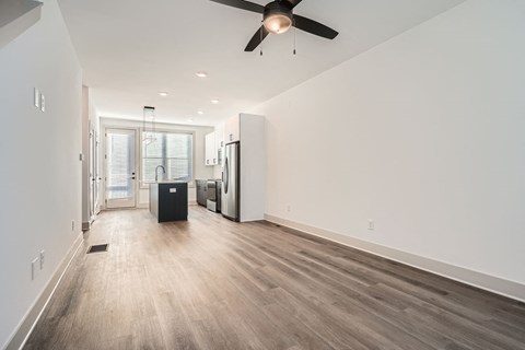 A spacious room with a ceiling fan and wooden flooring.