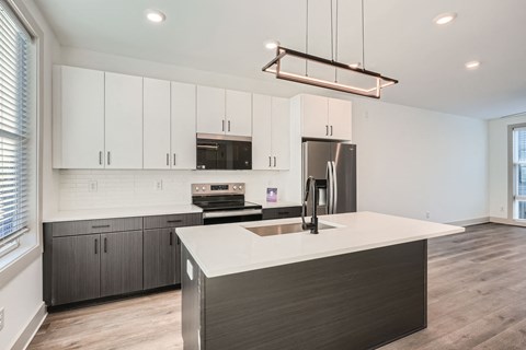 A modern kitchen with a large island and stainless steel appliances.