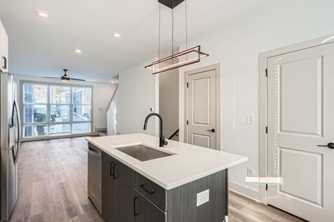 A modern kitchen with a large island and a refrigerator.