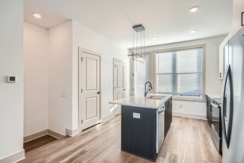 A kitchen with a black island and white appliances.