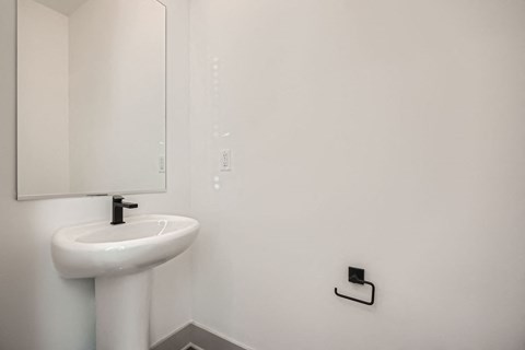 A white sink in a bathroom with a mirror above it.