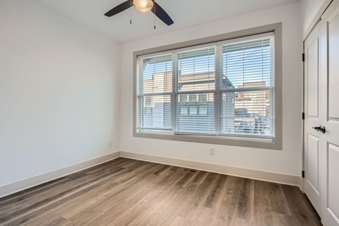 A room with a window and a ceiling fan.