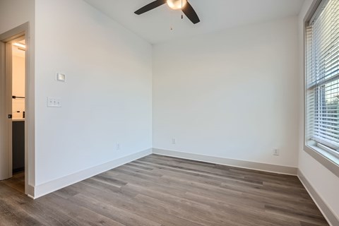 A room with a ceiling fan and light switch.