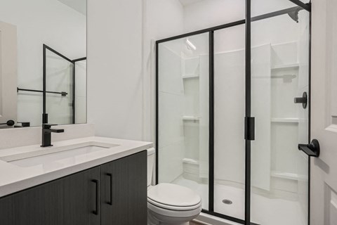 A bathroom with a white sink and a toilet.