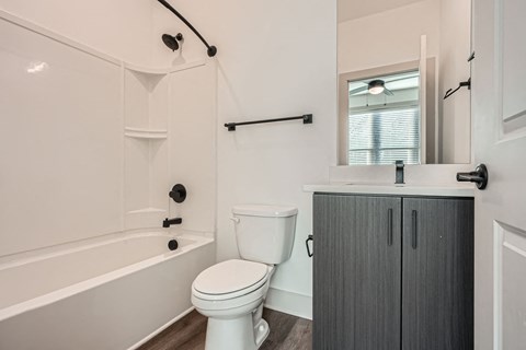 A white toilet sits next to a bathtub in a bathroom.