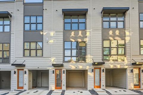 A building with grey siding and multiple windows and doors.