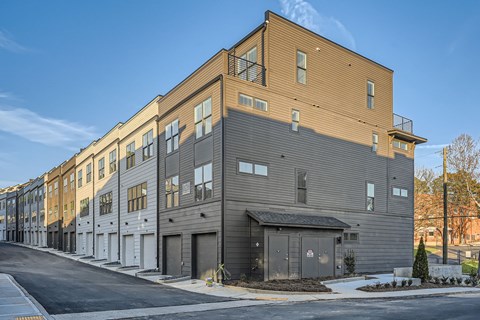 A modern apartment building with a mix of beige and grey exterior walls.