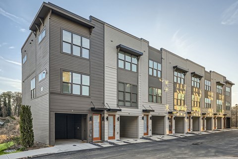 A modern apartment building with a mix of grey and beige exterior walls.