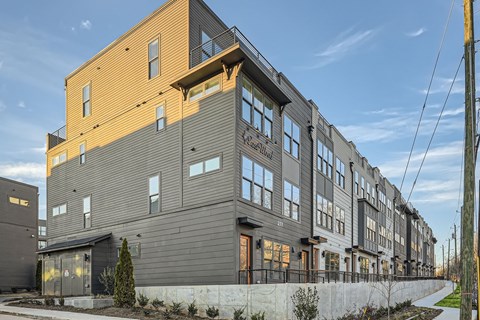 A modern apartment building with a mix of grey and yellow facades.