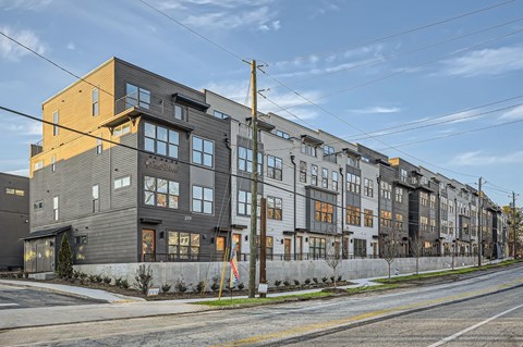A row of modern townhouses with a mix of grey and yellow facades.