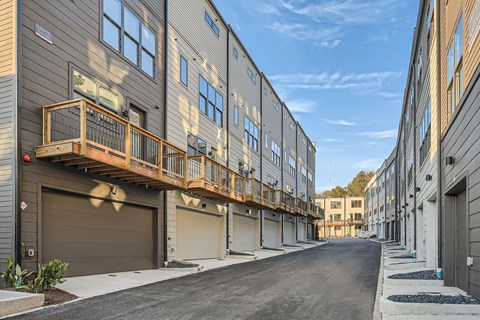 A row of modern townhouses with balconies and garages.