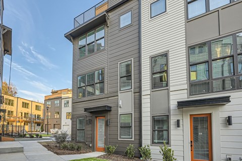 A modern apartment building with a mix of grey and beige exterior walls.