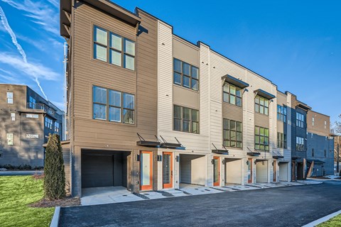 A row of modern townhouses with garages on the ground floor.