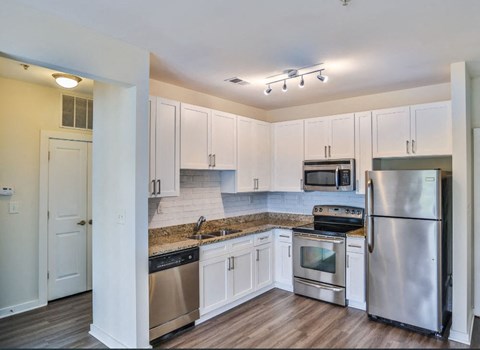 a kitchen with stainless steel appliances and white cabinets