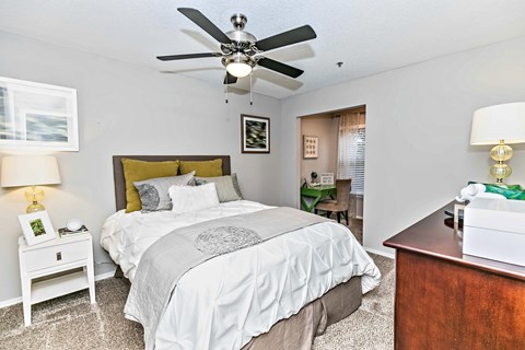 A bedroom with a large bed and a ceiling fan.