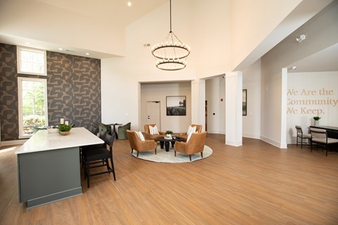 A modern living room with a grey sofa and a wooden floor.