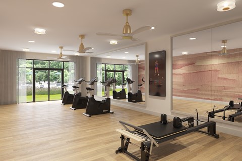 A gym with a row of treadmills and a row of stationary bikes.