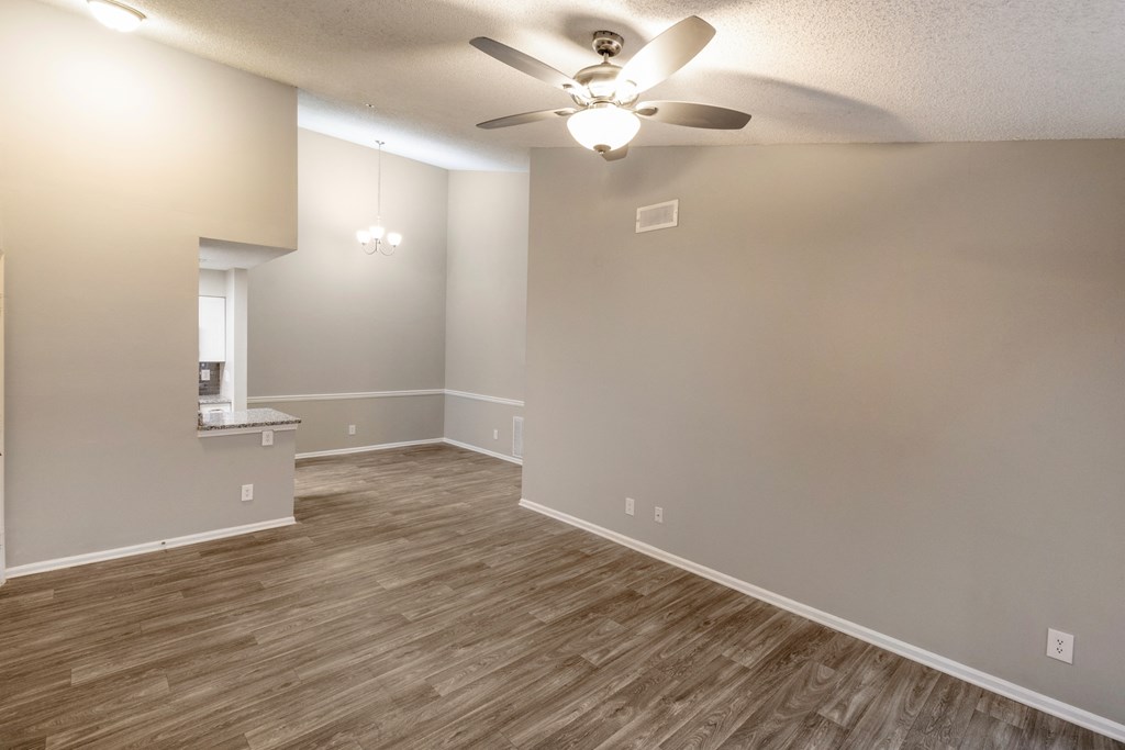an empty living room with a ceiling fan