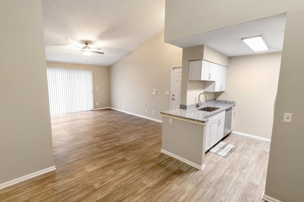 an empty room with a kitchen and a living room