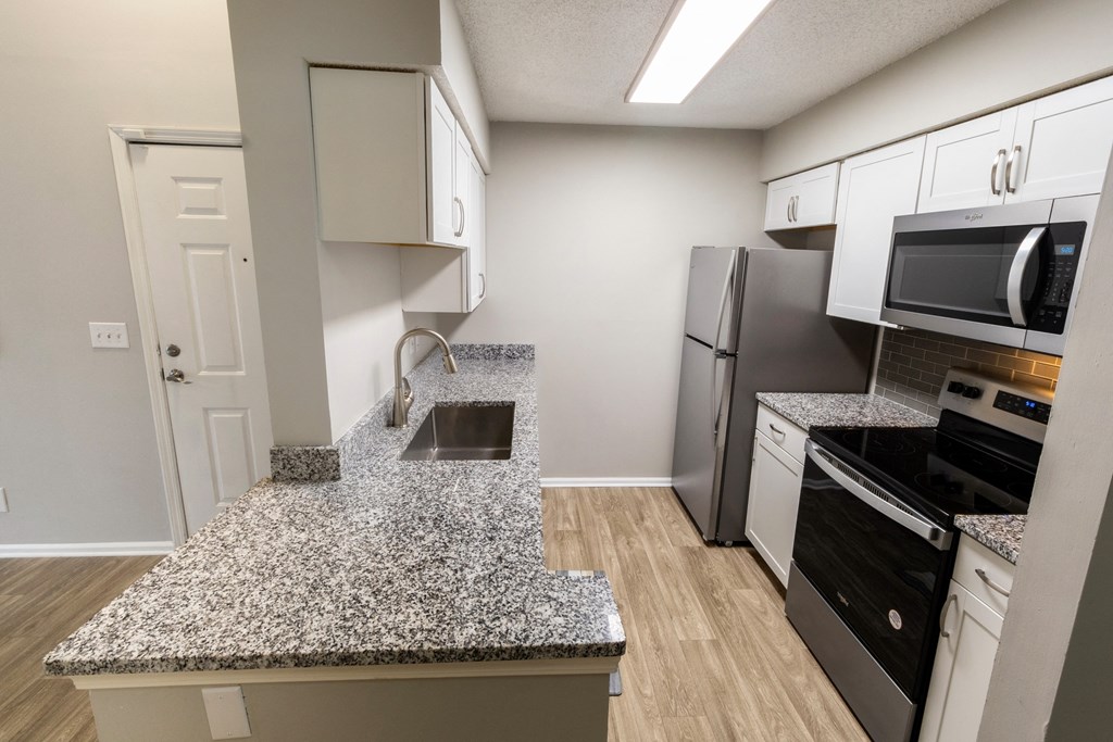 a kitchen with granite counter top and stainless steel appliances