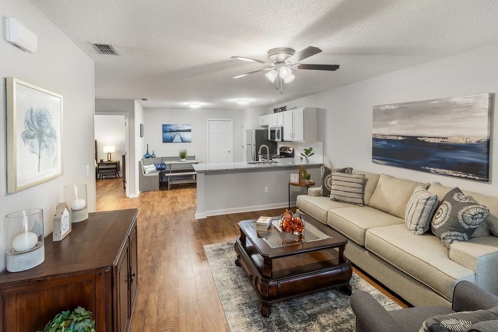 an open living room and kitchen with a couch and a coffee table