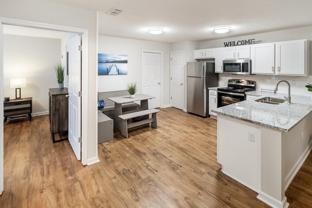 an open kitchen and living room with a kitchen island and stainless steel appliances