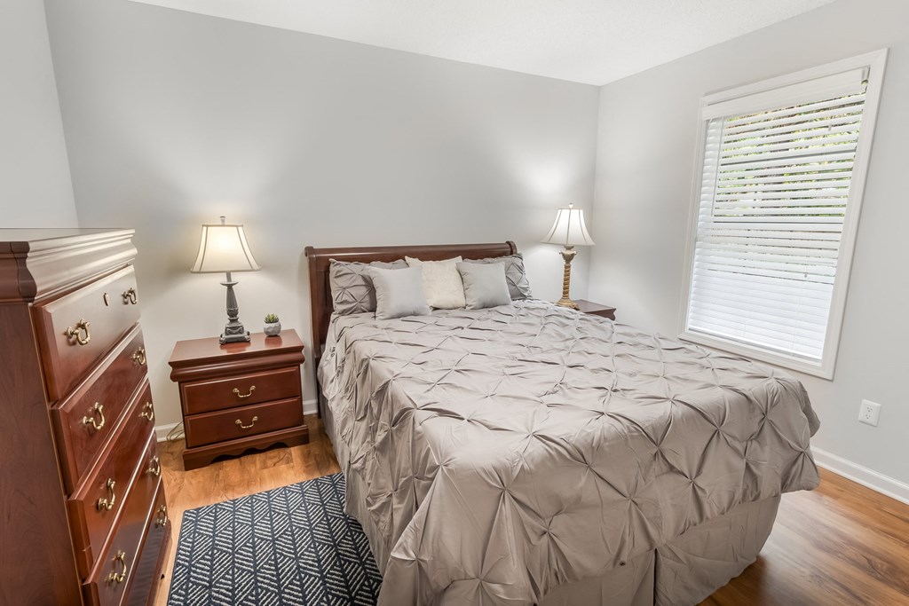 a bedroom with a bed and a dresser and a window