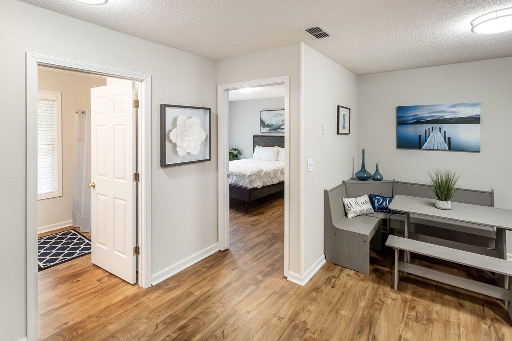 a living room with a desk and a bedroom with a bed