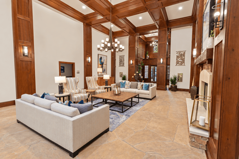 A spacious living room with a large sofa and a fireplace.