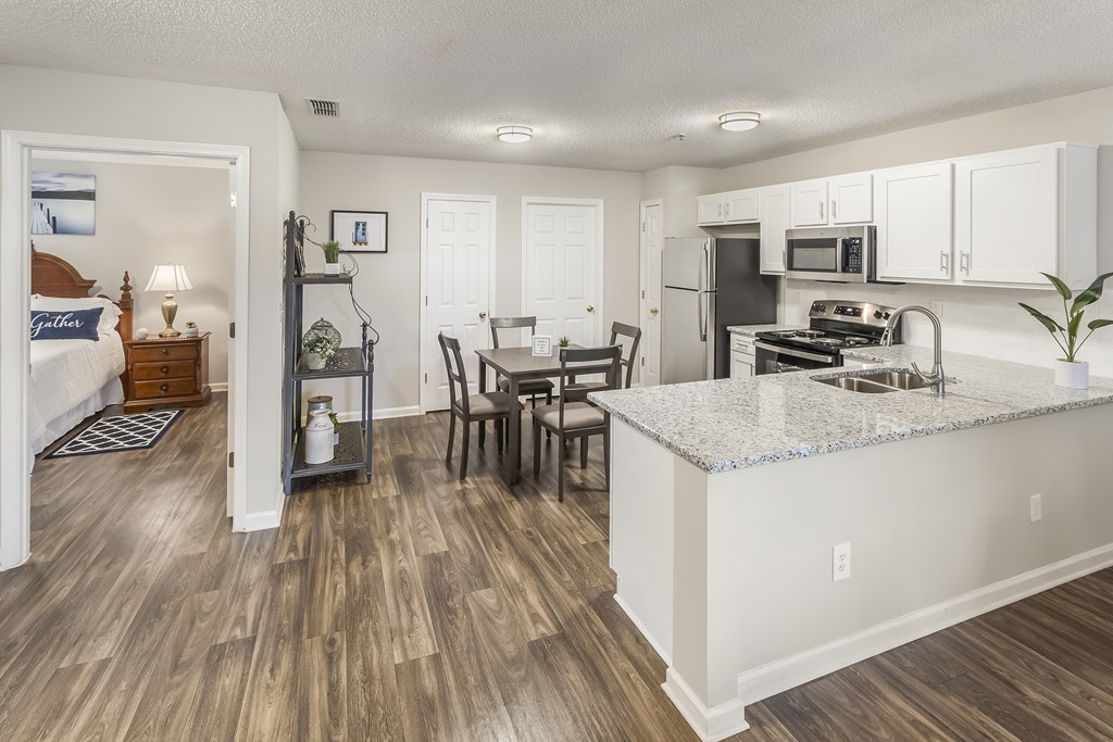 an open kitchen and living room with a dining room table and a kitchen counter top