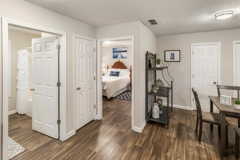 an open living room and dining room with a bedroom in the background